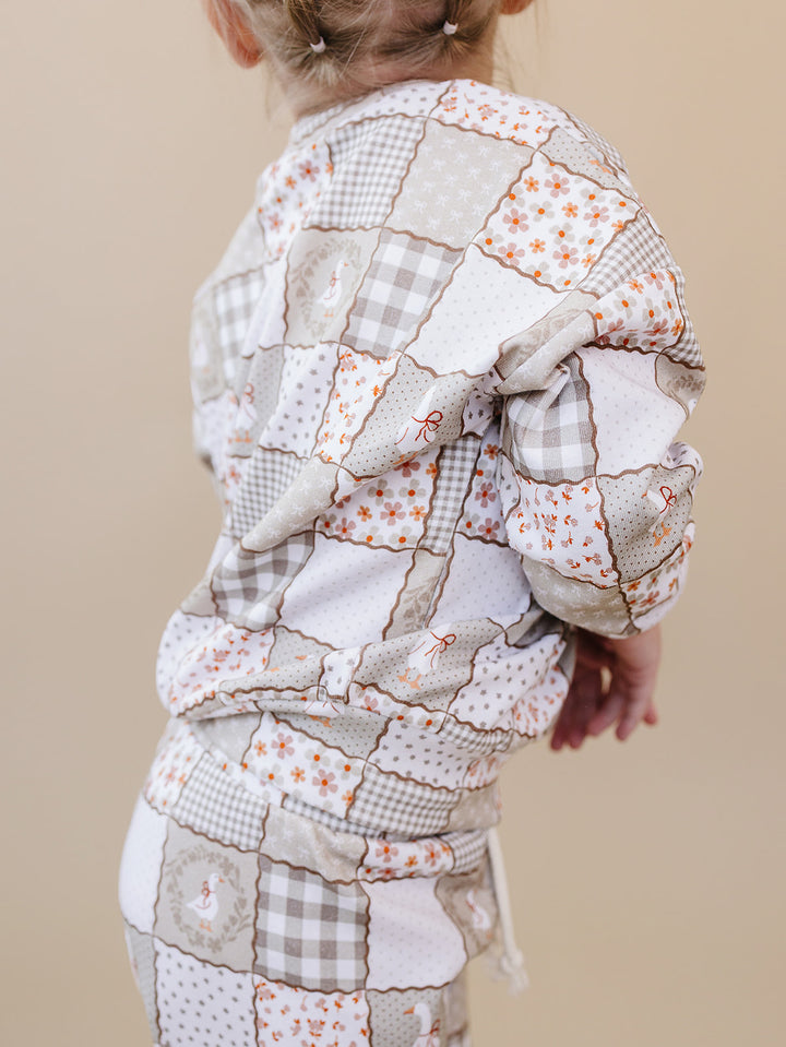 Close-up back view of a toddler wearing the Cottage Goose jogger set, showing the top and elastic-waist pants.
