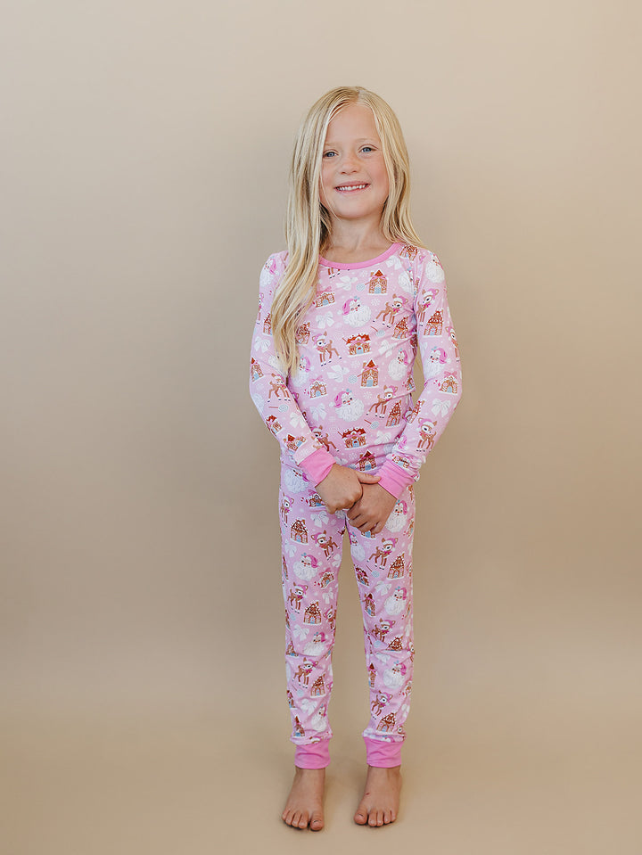 Front view of a child wearing Pink Christmas pajamas with hands held together.