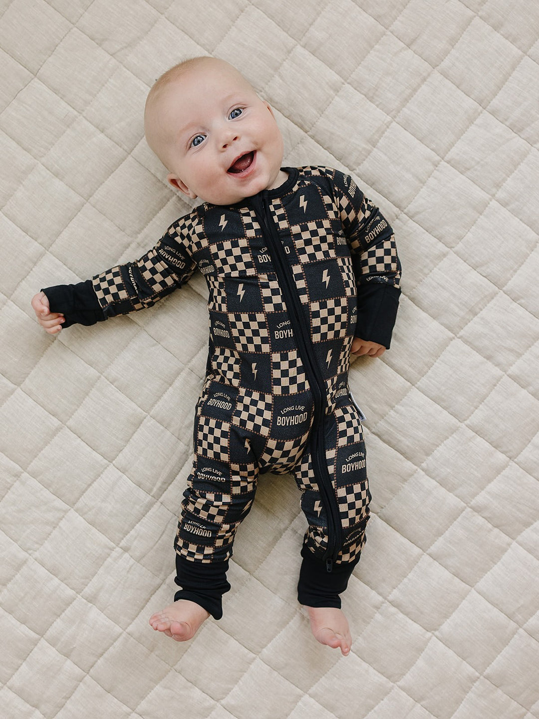 Close-up of a baby wearing the Long Live Boyhood bamboo romper, showing the checkered print and front zipper.