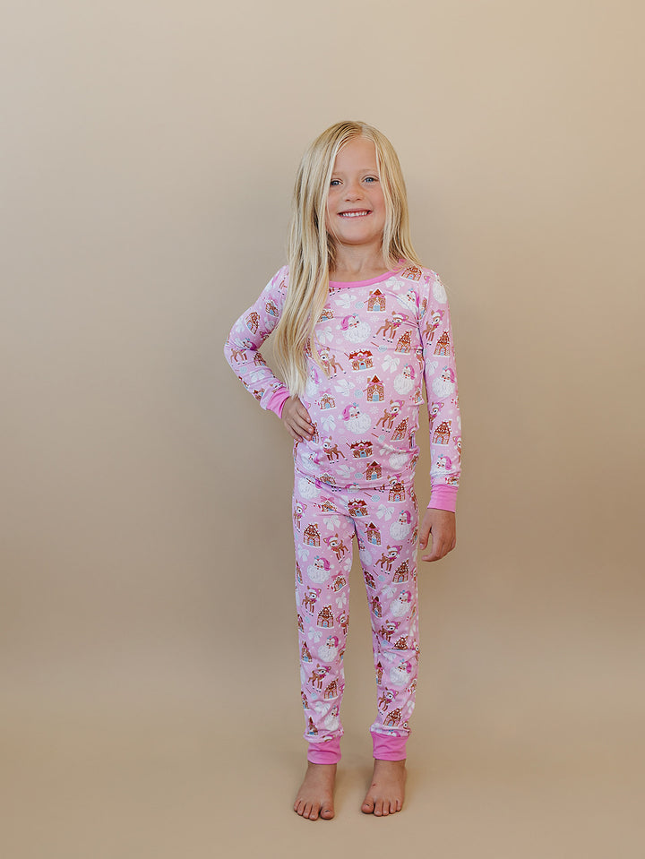 Child standing with a hand on their hip in the Pink Christmas two piece pajama set.