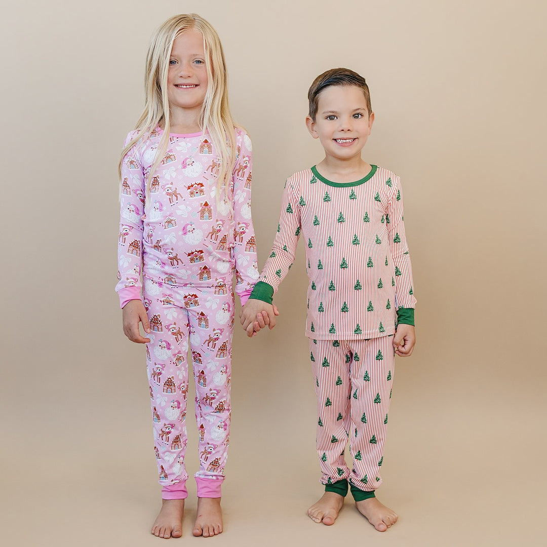 Two children holding hands in Pink Christmas and Magical Trees two piece Christmas pajamas.