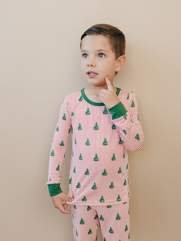 Child looking to the side in the Magical Trees Christmas pajama top with a green neckline.