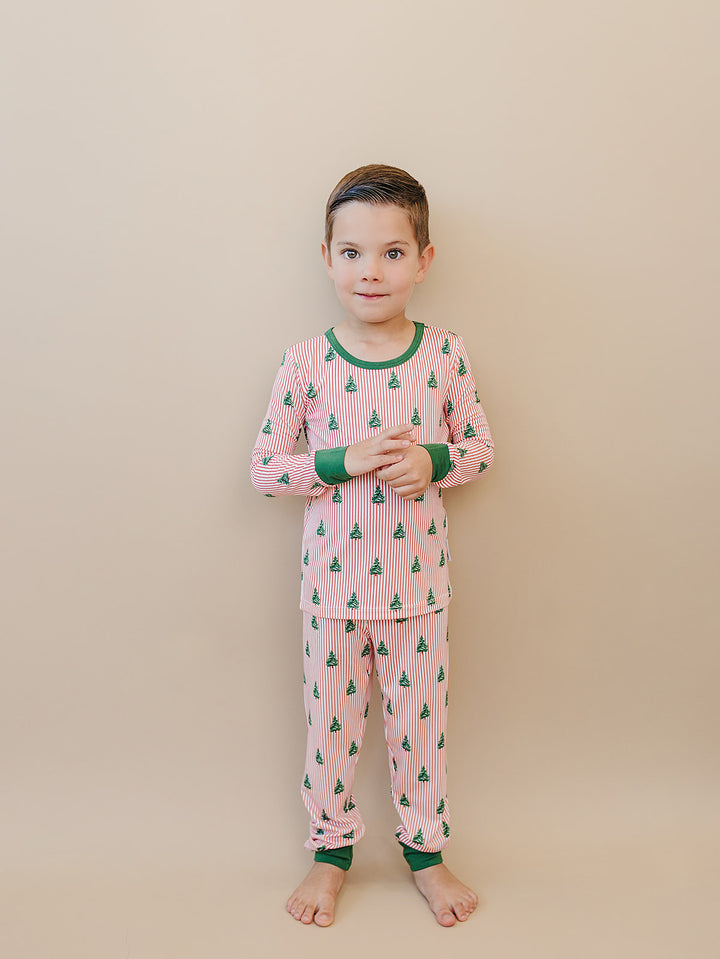 Child wearing Magical Trees two piece pajamas with hands held together in front.