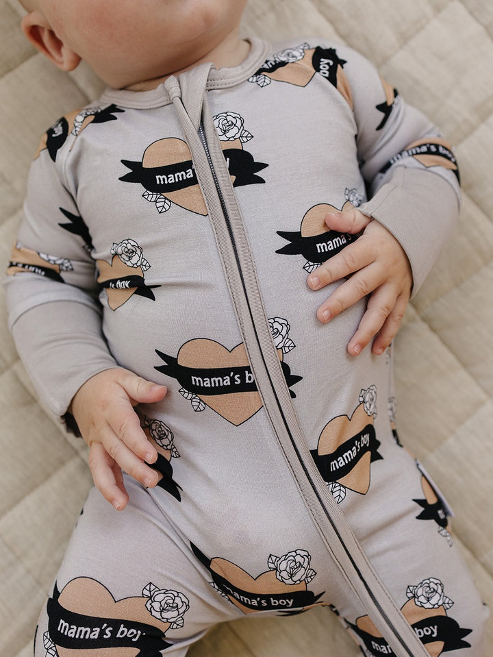 Close-up of the front zipper and heart-and-banner print on the Mama’s Boy bamboo romper.