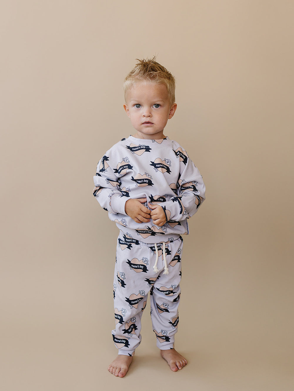 Toddler standing in the Mama’s Boy cotton long-sleeve top and matching jogger pants.