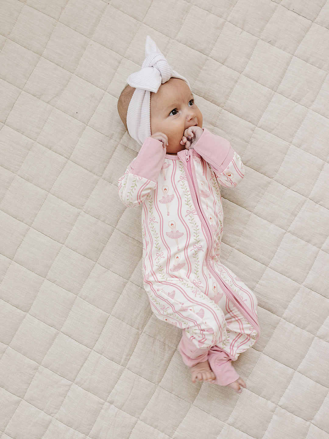 Side view of a baby wearing the Little Ballerina bamboo romper with convertible footies.
