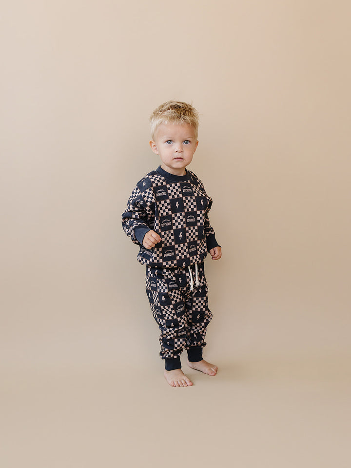 Full-length view of a toddler wearing the Long Live Boyhood checkered cotton top and jogger pants.