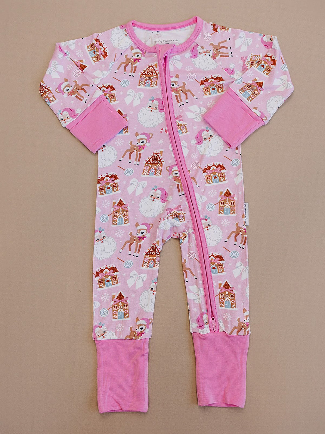 Pink Christmas zip romper laid flat, showing long sleeves, pink cuffs and a festive Santa and reindeer print.