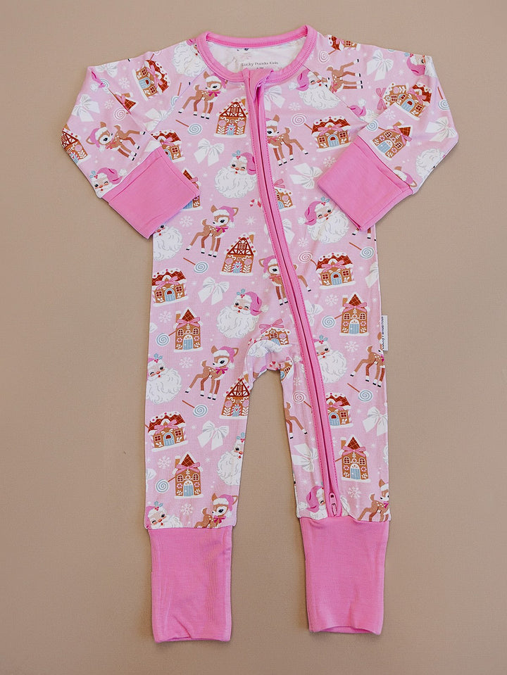 Pink Christmas zip romper laid flat, showing long sleeves, pink cuffs and a festive Santa and reindeer print.