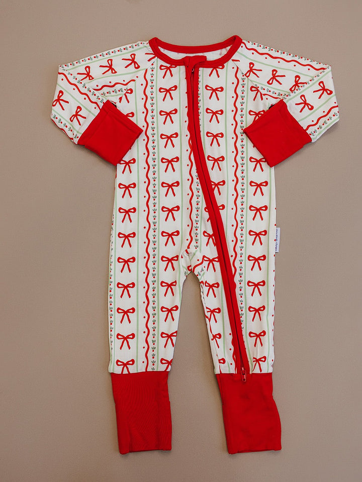 Christmas Bows zip romper laid flat, showing long sleeves, red cuffs and a red front zipper.