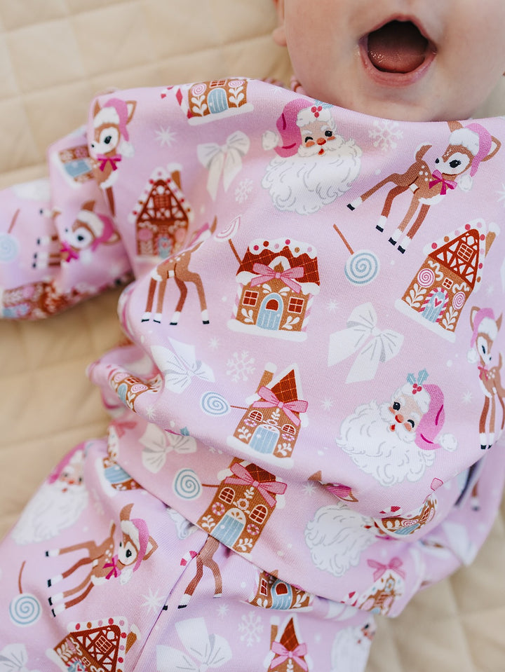 Close up of a baby wearing the Pink Christmas jogger set, showing the holiday print and waistband.
