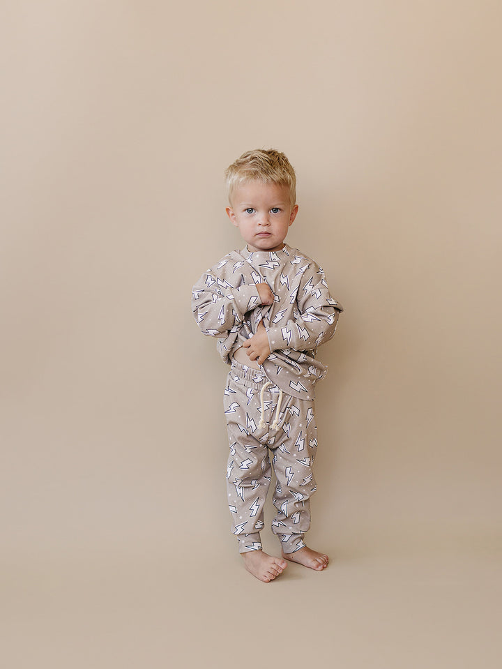 Toddler boy modeling the Latte Bolts jogger set in a full-length front studio view.
