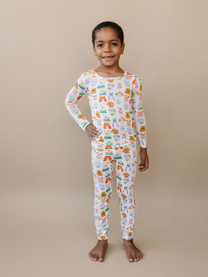 Child standing with one hand on their hip in the Puppy Club dog-print bamboo top and matching pants.