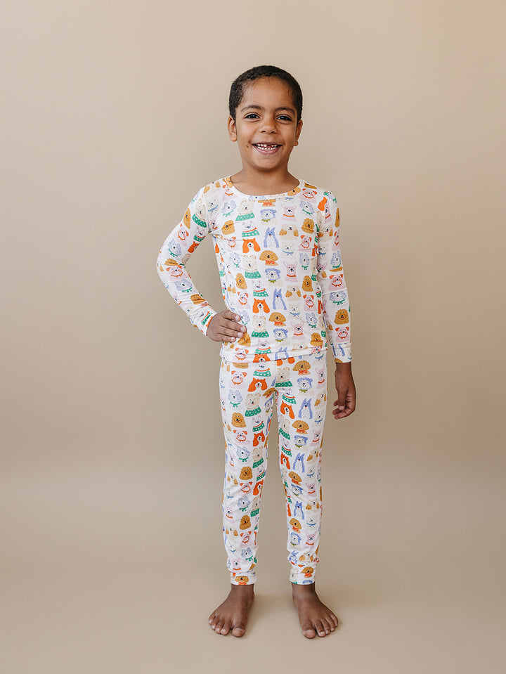Child sitting cross-legged in the Puppy Club bamboo two-piece set.