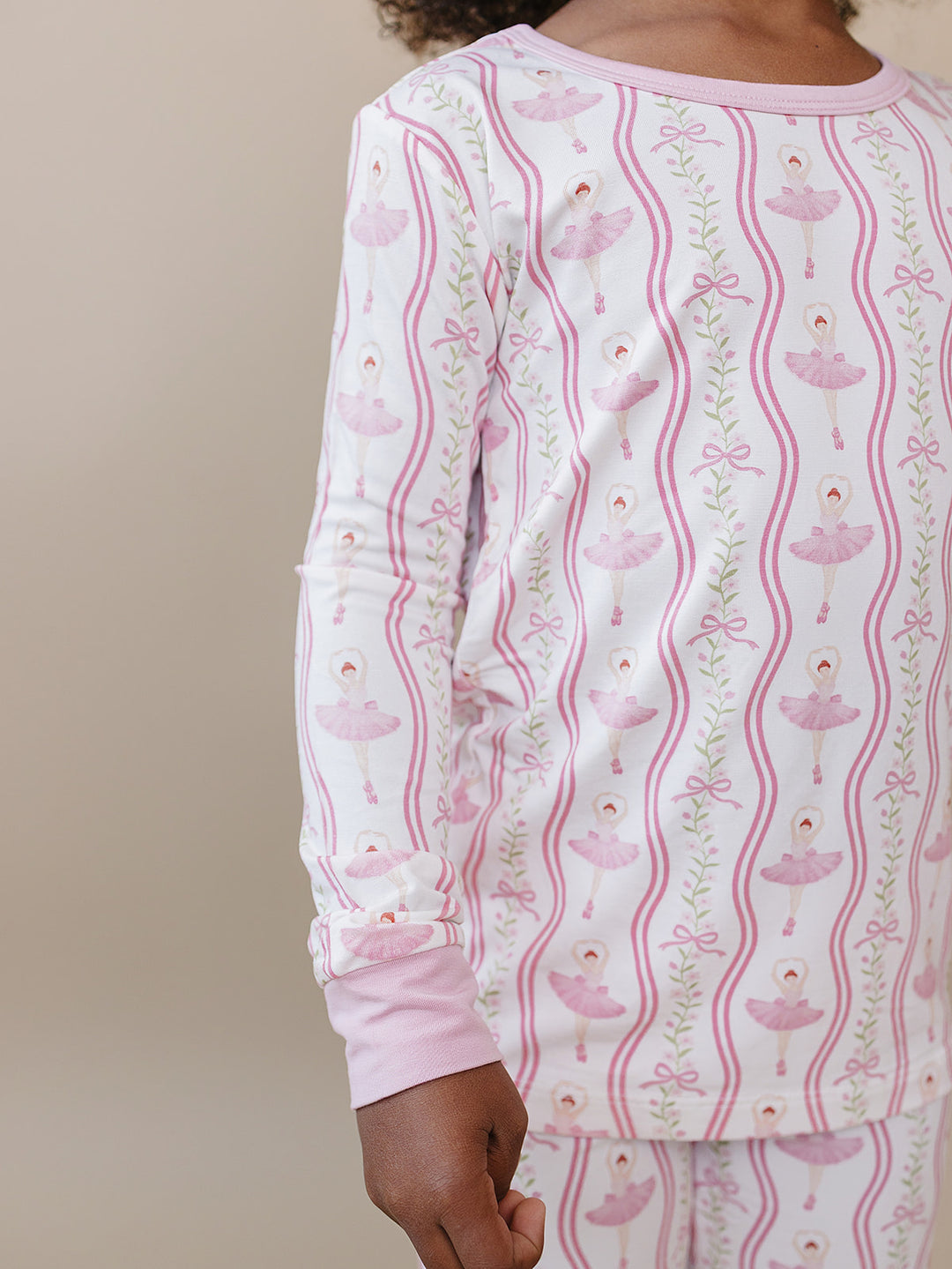 Close-up of a child wearing the Little Ballerina bamboo two-piece set with pink ballerina print.