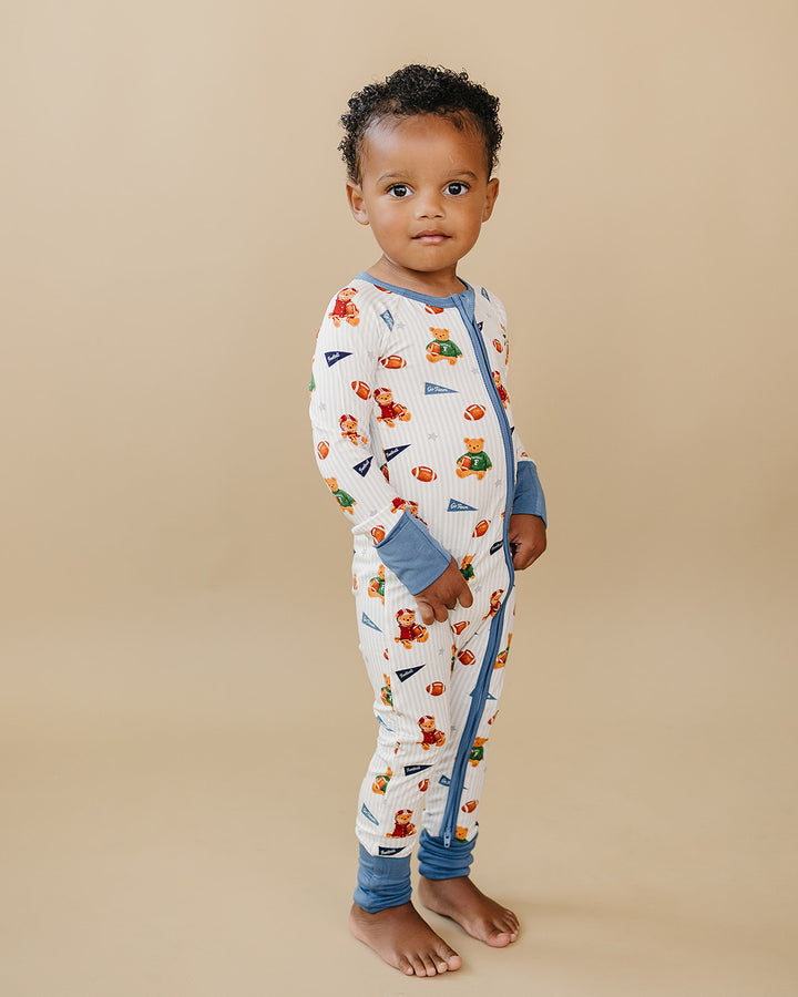 Child standing in the Touchdown Teddy bamboo romper against a neutral background.