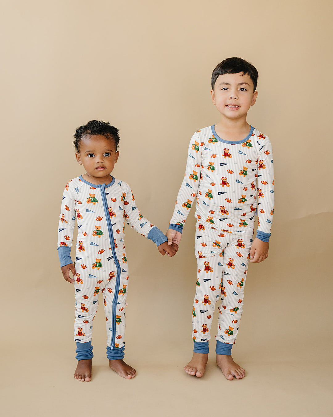 Two children wearing matching Touchdown Teddy bamboo two-piece outfits.