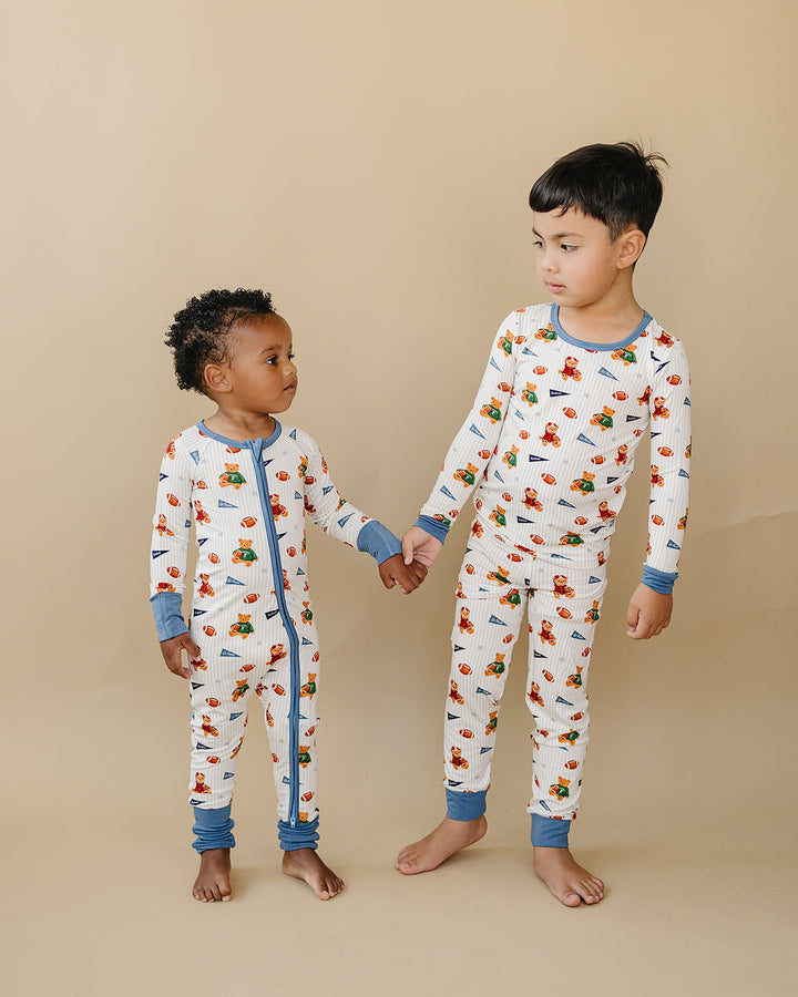 Two children wearing matching Touchdown Teddy football and teddy bear-print bamboo outfits.