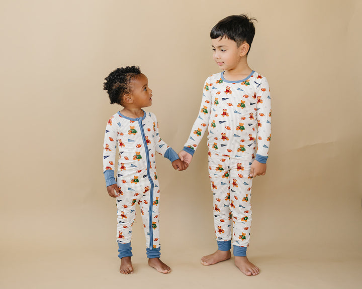 Two children modeling matching Touchdown Teddy bamboo two-piece sets.