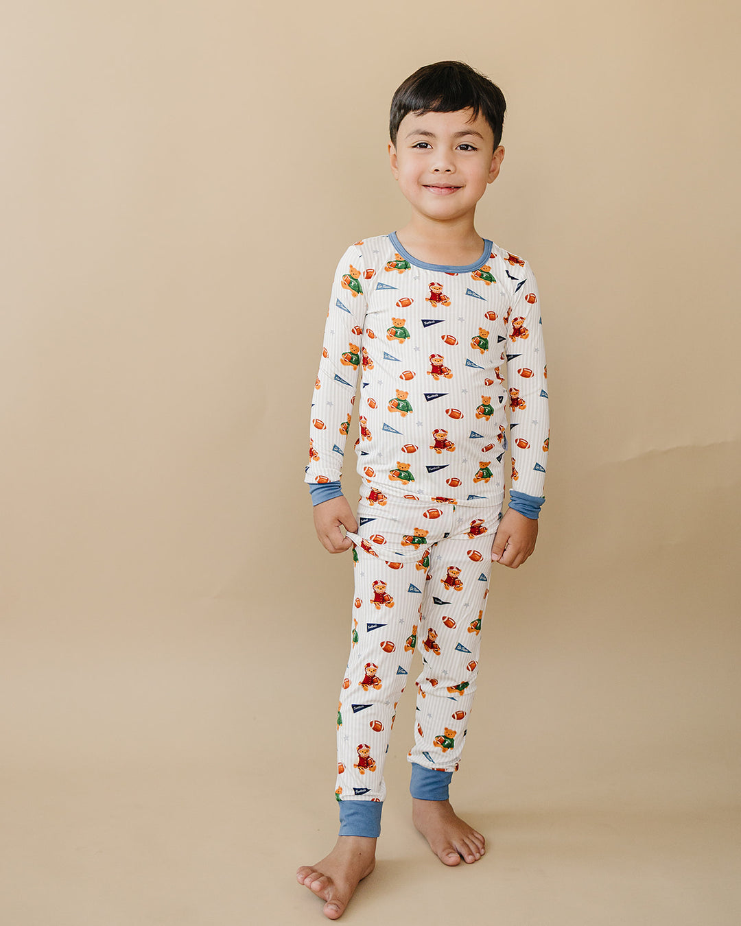 Child wearing the Touchdown Teddy long-sleeve bamboo top and matching pants.