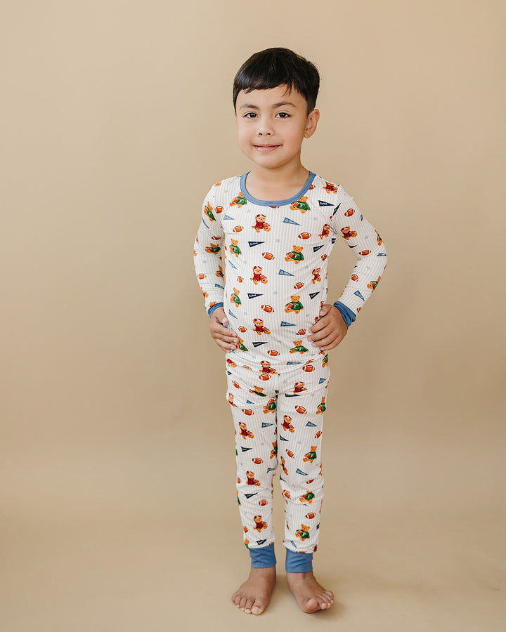 Full-length front view of a child modeling the Touchdown Teddy bamboo pajama set.