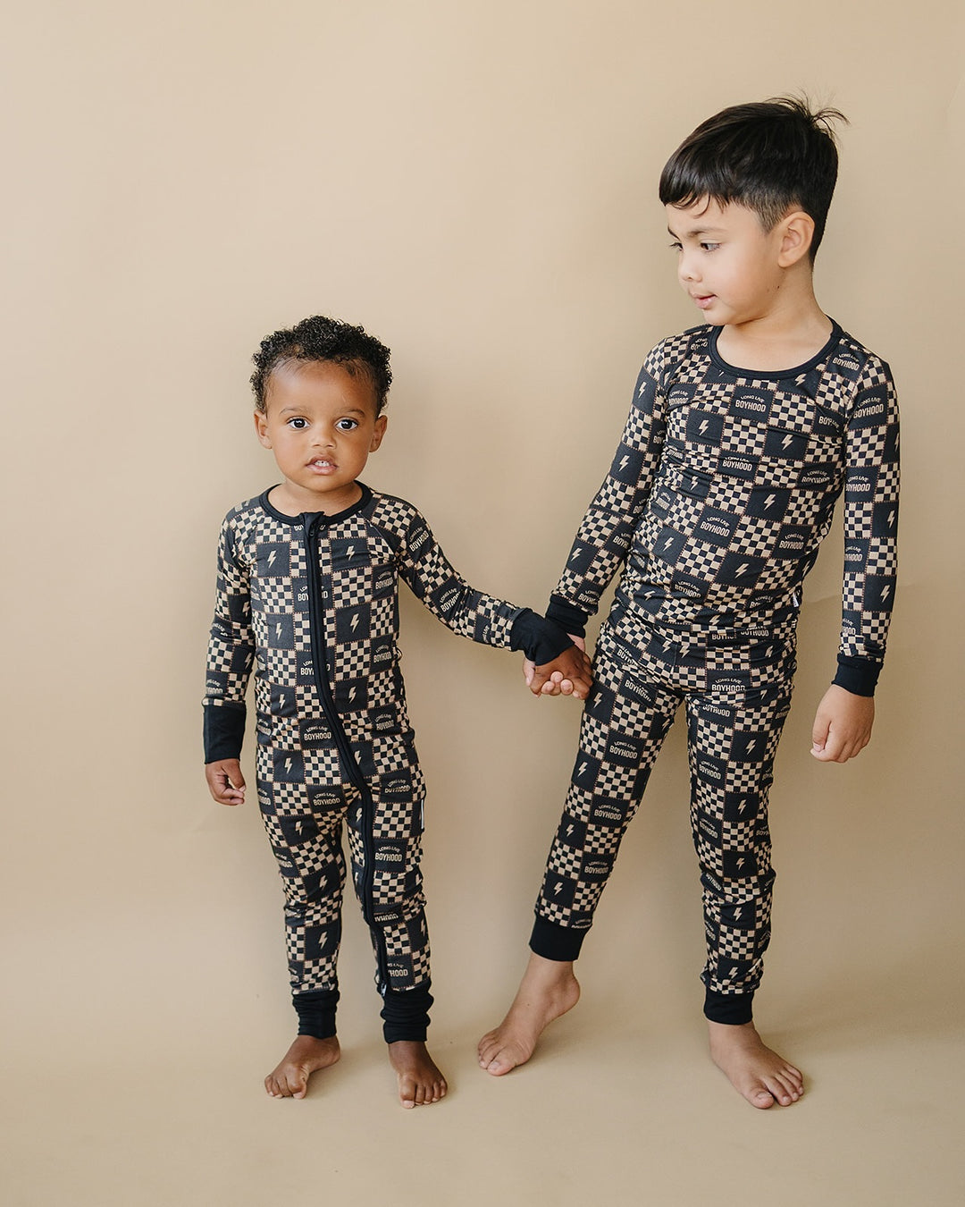 Children standing together in matching Long Live Boyhood checkered bamboo outfits.