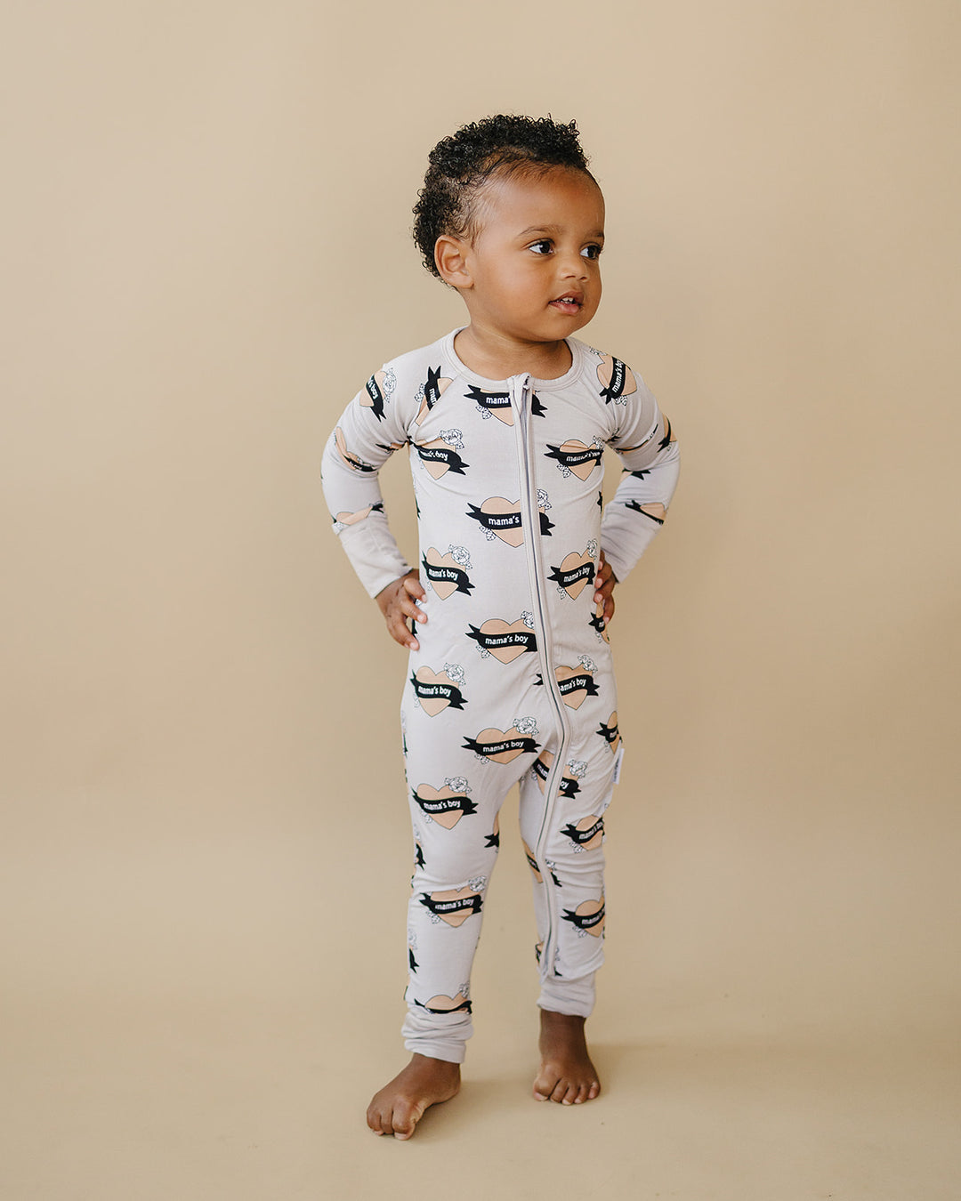 Toddler standing with hands on hips in the Mama’s Boy bamboo zip romper.