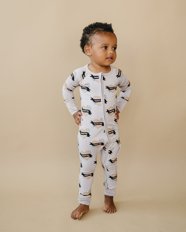 Toddler standing with hands on hips in the Mama’s Boy bamboo zip romper.