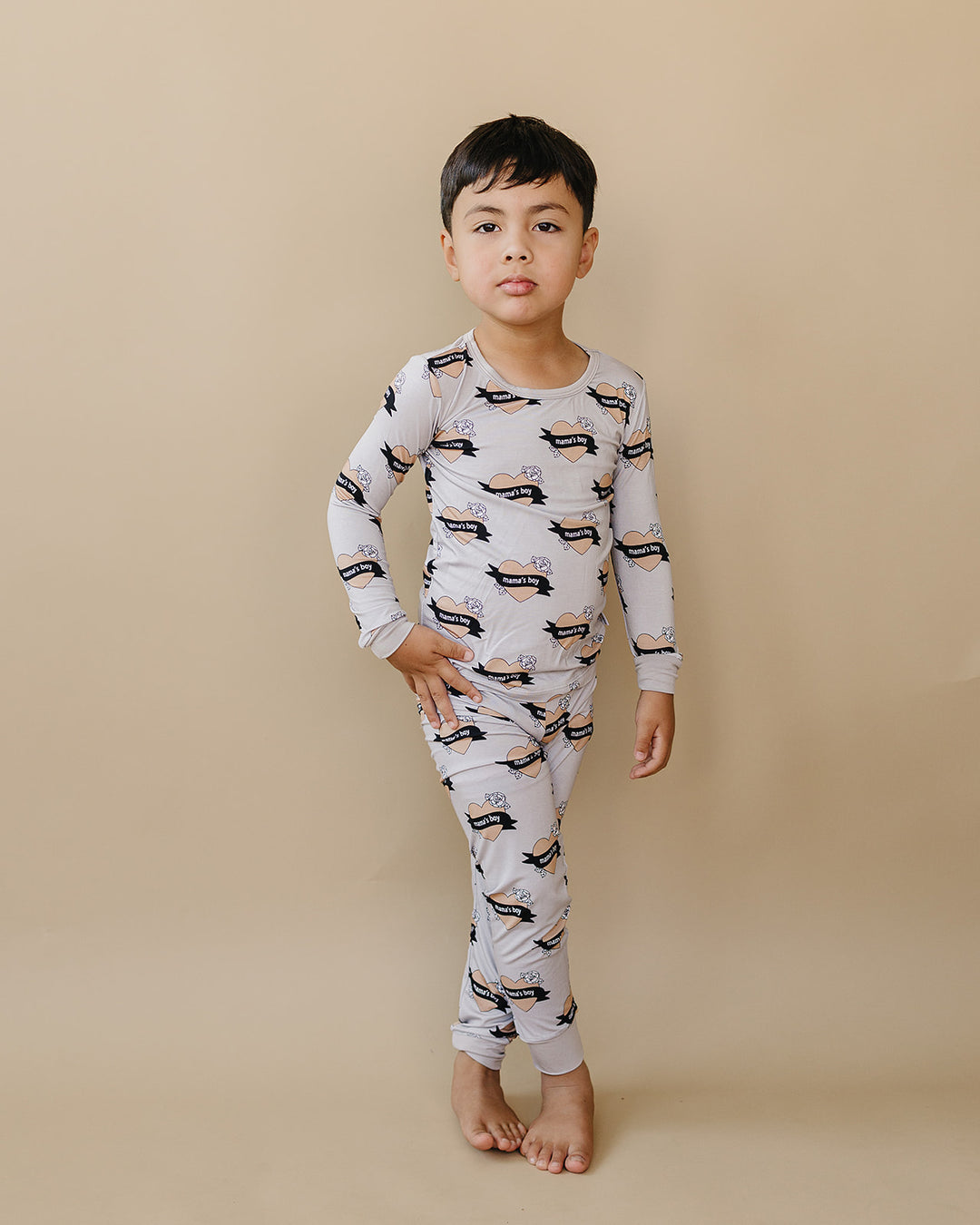Child standing with one hand at their hip in the Mama’s Boy bamboo two-piece set.