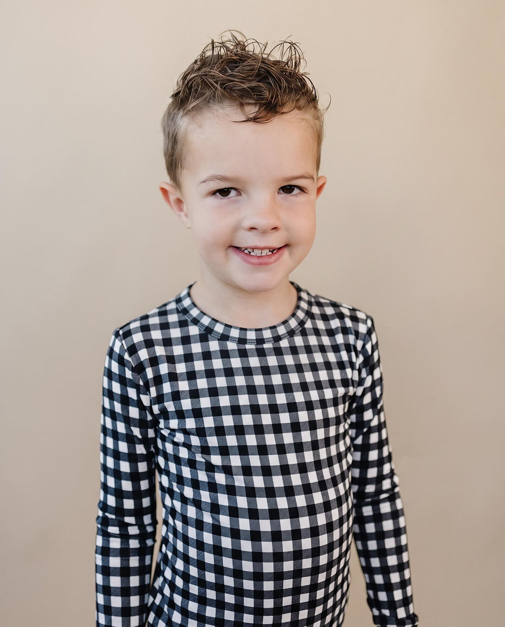 Child wearing the Black Gingham Bamboo Two Piece Set with classic black and white check print