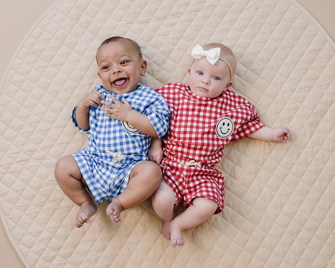 Baby wearing Lucky Panda Kids Red Gingham Shorts Set — gender neutral cotton two-piece with smiley face patch
Lucky Panda Kids Shorts Set Red Gingham flat lay — relaxed top with smiley patch and matching elastic waistband shorts
Toddler in Lucky Panda Kids Red Gingham Shorts Set — sizes 0–3M to 8–9Y, gender neutral summer outfit
Close-up of Lucky Panda Kids Red Gingham Shorts Set smiley face patch — soft 95% cotton kids two-piece
Lucky Panda Kids Red Gingham Shorts Set on baby — gender neutral cotton summer