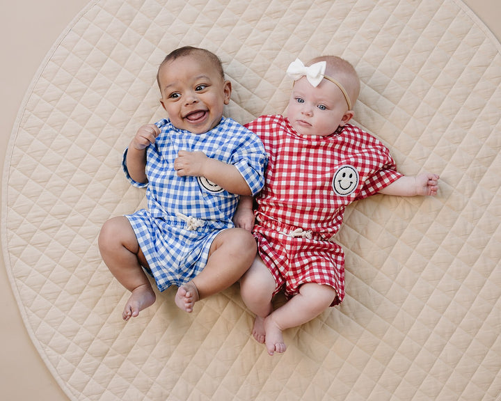 Baby wearing Lucky Panda Kids Blue Gingham Shorts Set — gender neutral cotton two-piece with smiley face patch
Lucky Panda Kids Shorts Set Blue Gingham flat lay — relaxed top with smiley patch and matching elastic waistband shorts
Toddler in Lucky Panda Kids Blue Gingham Shorts Set — sizes 0–3M to 8–9Y, gender neutral summer outfit
Close-up of Lucky Panda Kids Blue Gingham Shorts Set smiley face patch — soft 95% cotton kids two-piece
Lucky Panda Kids Blue Gingham Shorts Set on babies — gender neutral cotton