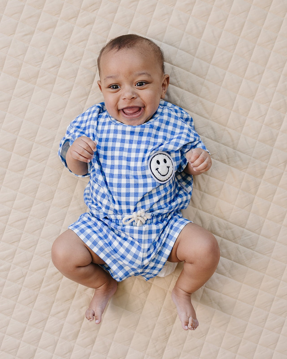 Baby wearing Lucky Panda Kids Blue Gingham Shorts Set — gender neutral cotton two-piece with smiley face patch
Lucky Panda Kids Shorts Set Blue Gingham flat lay — relaxed top with smiley patch and matching elastic waistband shorts
Toddler in Lucky Panda Kids Blue Gingham Shorts Set — sizes 0–3M to 8–9Y, gender neutral summer outfit
Close-up of Lucky Panda Kids Blue Gingham Shorts Set smiley face patch — soft 95% cotton kids two-piece
Lucky Panda Kids Blue Gingham Shorts Set on babies — gender neutral cotton
