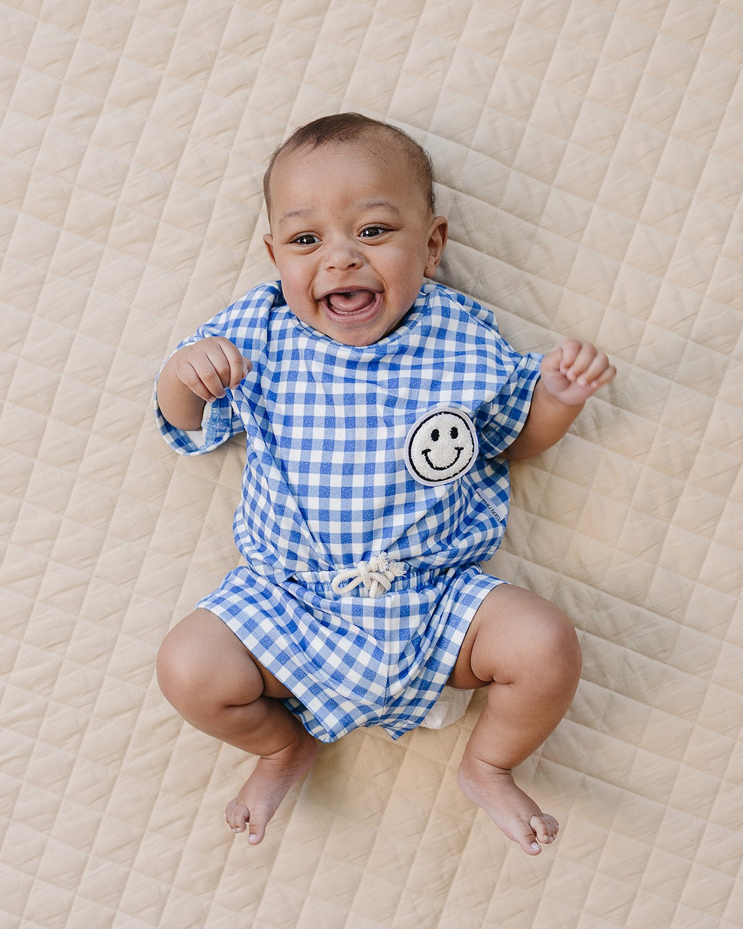 Baby wearing Lucky Panda Kids Blue Gingham Shorts Set — gender neutral cotton two-piece with smiley face patch
Lucky Panda Kids Shorts Set Blue Gingham flat lay — relaxed top with smiley patch and matching elastic waistband shorts
Toddler in Lucky Panda Kids Blue Gingham Shorts Set — sizes 0–3M to 8–9Y, gender neutral summer outfit
Close-up of Lucky Panda Kids Blue Gingham Shorts Set smiley face patch — soft 95% cotton kids two-piece
Lucky Panda Kids Blue Gingham Shorts Set on babies — gender neutral cotton