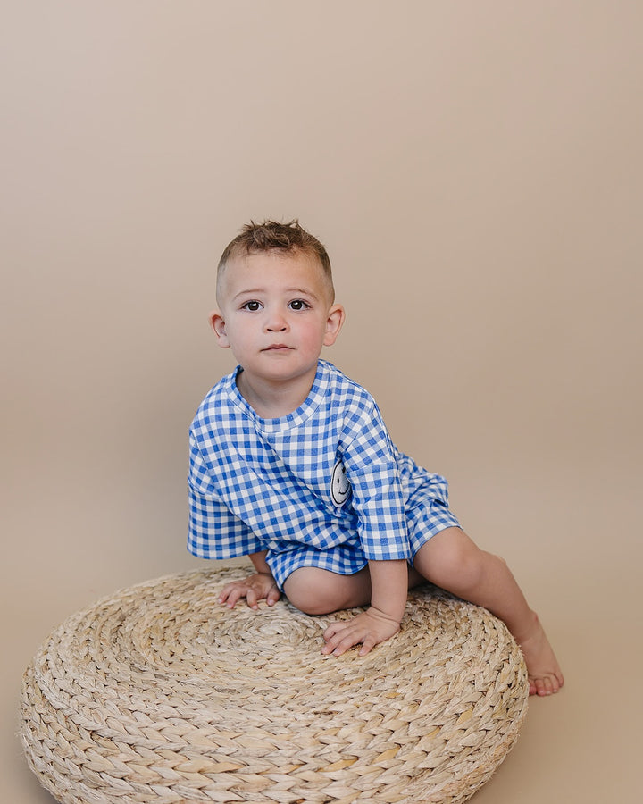 Baby wearing Lucky Panda Kids Blue Gingham Shorts Set — gender neutral cotton two-piece with smiley face patch
Lucky Panda Kids Shorts Set Blue Gingham flat lay — relaxed top with smiley patch and matching elastic waistband shorts
Toddler in Lucky Panda Kids Blue Gingham Shorts Set — sizes 0–3M to 8–9Y, gender neutral summer outfit
Close-up of Lucky Panda Kids Blue Gingham Shorts Set smiley face patch — soft 95% cotton kids two-piece
Lucky Panda Kids Blue Gingham Shorts Set on babies — gender neutral cotton