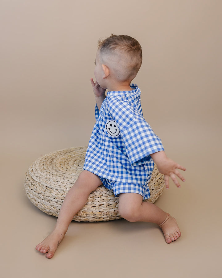 Baby wearing Lucky Panda Kids Blue Gingham Shorts Set — gender neutral cotton two-piece with smiley face patch
Lucky Panda Kids Shorts Set Blue Gingham flat lay — relaxed top with smiley patch and matching elastic waistband shorts
Toddler in Lucky Panda Kids Blue Gingham Shorts Set — sizes 0–3M to 8–9Y, gender neutral summer outfit
Close-up of Lucky Panda Kids Blue Gingham Shorts Set smiley face patch — soft 95% cotton kids two-piece
Lucky Panda Kids Blue Gingham Shorts Set on babies — gender neutral cotton