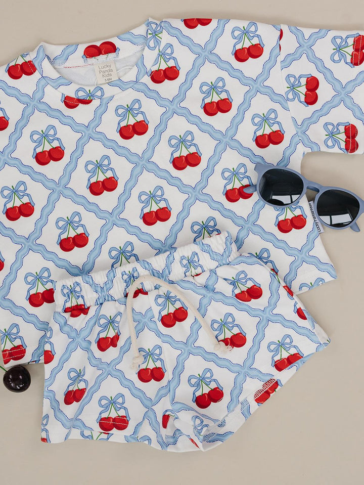 Lucky Panda Kids Sweet Cherry Cotton Shorts Set flat lay — top and shorts.Close-up of Sweet Cherry Cotton Shorts Set fabric showing cherry print and soft cotton texture