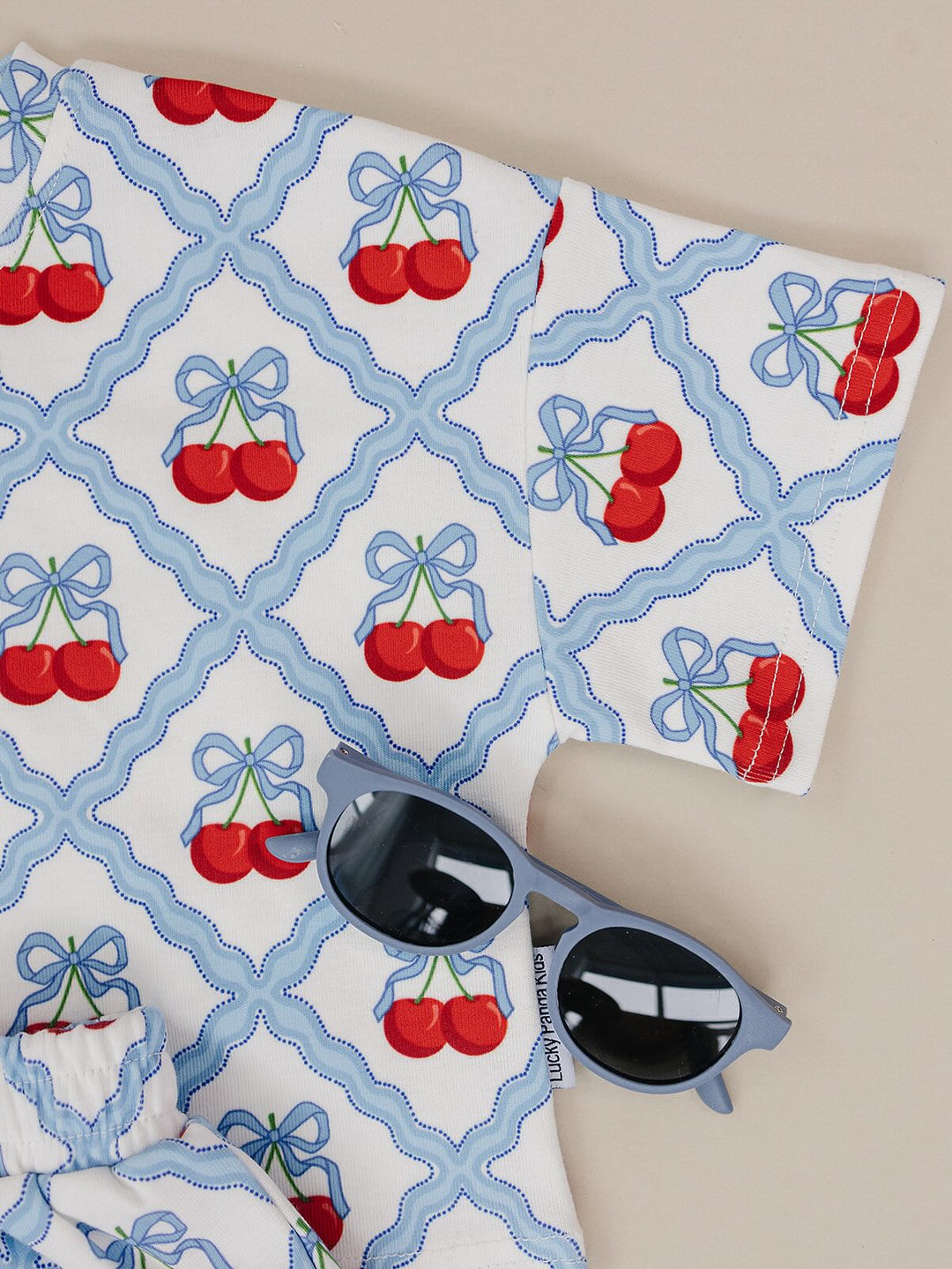 Lucky Panda Kids Sweet Cherry Cotton Shorts Set flat lay — top and shorts.Close-up of Sweet Cherry Cotton Shorts Set fabric showing cherry print and soft cotton texture