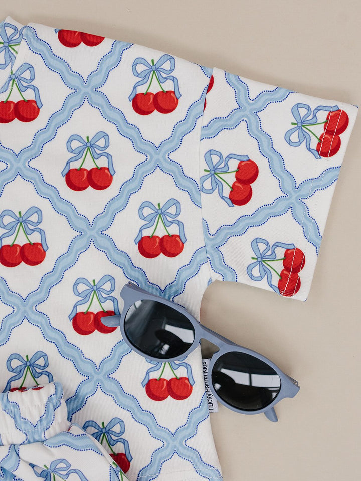 Lucky Panda Kids Sweet Cherry Cotton Shorts Set flat lay — top and shorts.Close-up of Sweet Cherry Cotton Shorts Set fabric showing cherry print and soft cotton texture