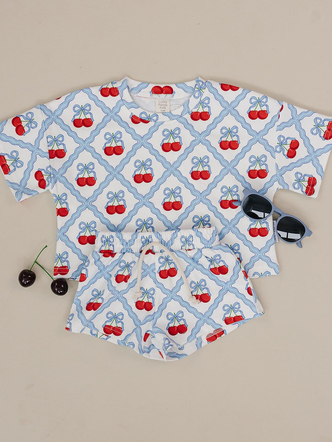 Lucky Panda Kids Sweet Cherry Cotton Shorts Set flat lay — top and shorts.Close-up of Sweet Cherry Cotton Shorts Set fabric showing cherry print and soft cotton texture