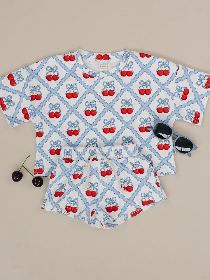 Lucky Panda Kids Sweet Cherry Cotton Shorts Set flat lay — top and shorts.Close-up of Sweet Cherry Cotton Shorts Set fabric showing cherry print and soft cotton texture