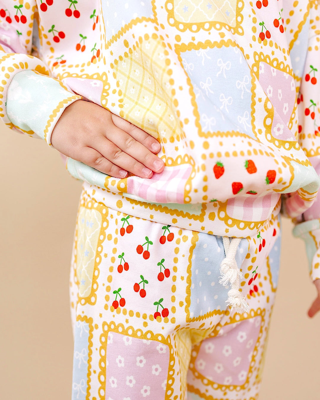 Close up of the Sweet Patchwork jogger set showing the top hem, waistband and pastel patchwork print.