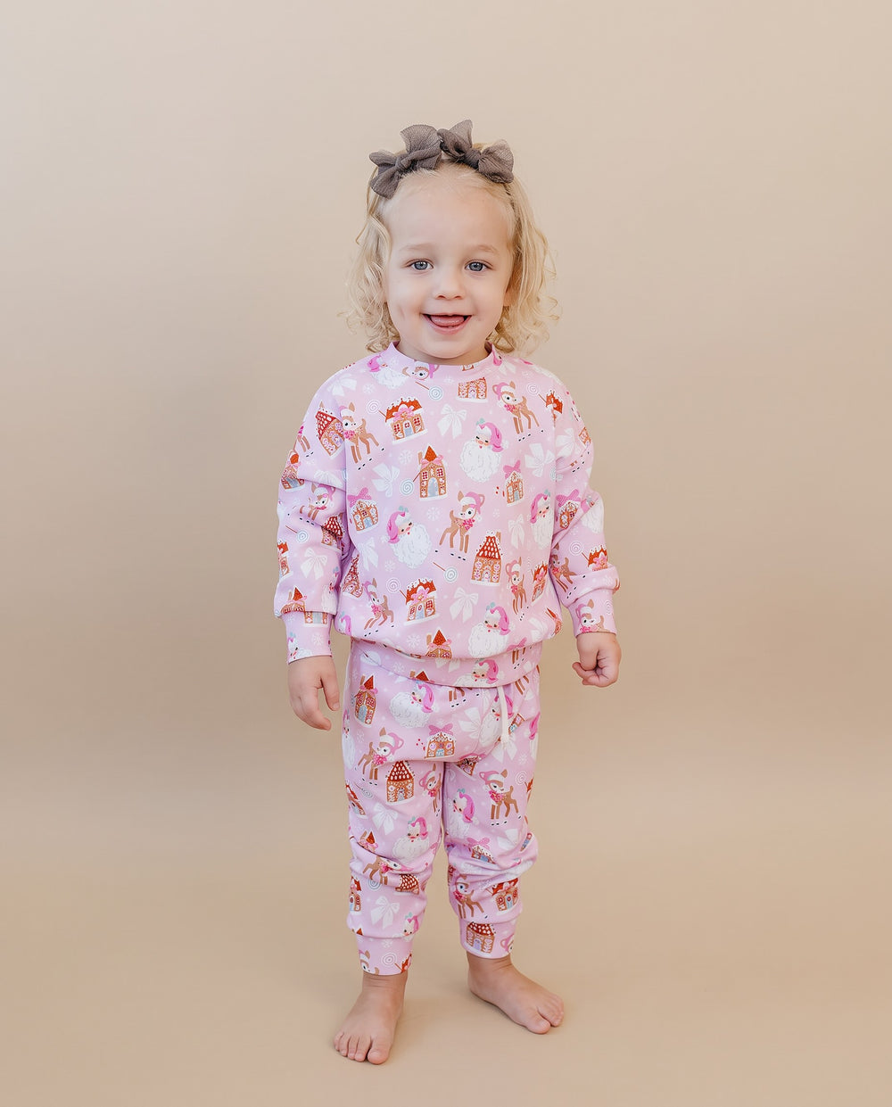 Toddler standing in the Pink Christmas long sleeve top and matching jogger pants.