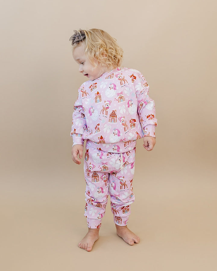 Toddler looking over one shoulder in the Pink Christmas jogger set, showing the back of the top and pants.