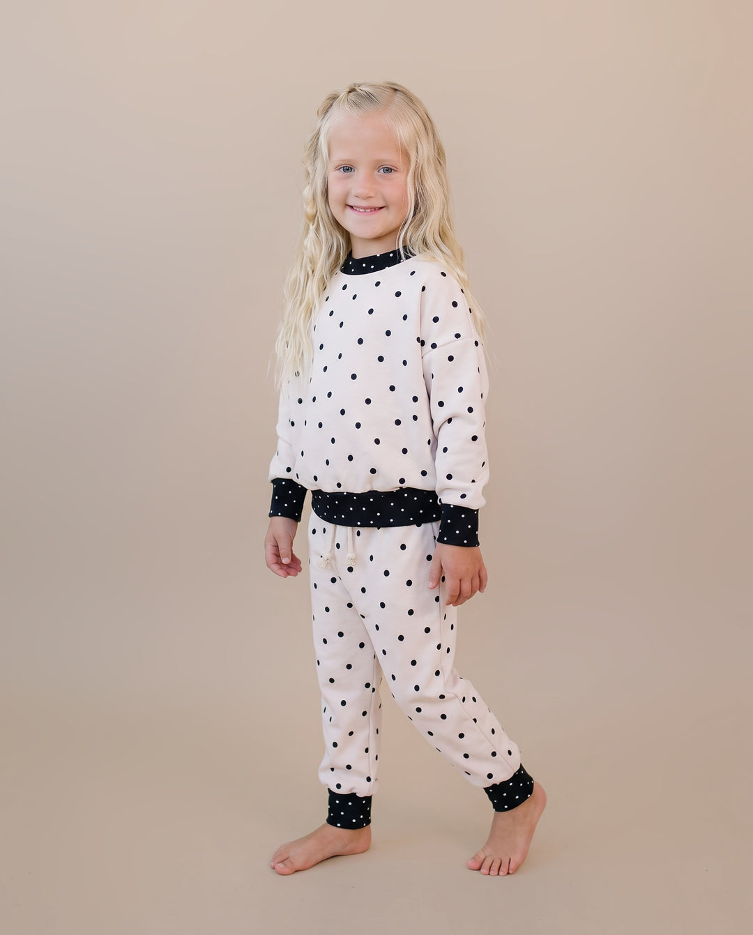 Little one wearing the Classic Polka Jogger Set in a black polka dot print on white