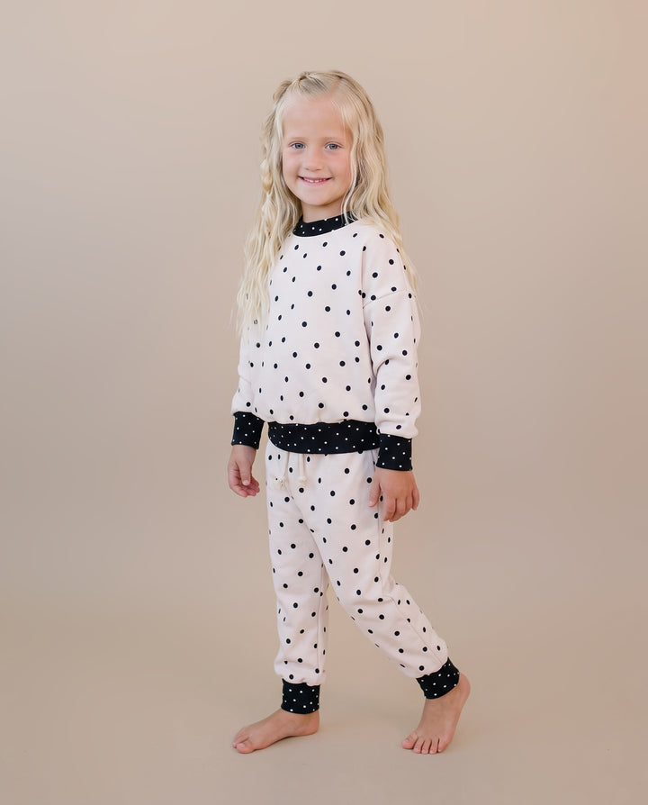 Little one wearing the Classic Polka Jogger Set in a black polka dot print on white
