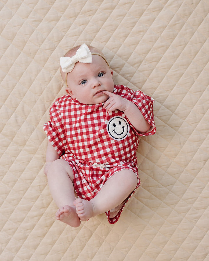 Baby wearing Lucky Panda Kids Red Gingham Shorts Set — gender neutral cotton two-piece with smiley face patch
Lucky Panda Kids Shorts Set Red Gingham flat lay — relaxed top with smiley patch and matching elastic waistband shorts
Toddler in Lucky Panda Kids Red Gingham Shorts Set — sizes 0–3M to 8–9Y, gender neutral summer outfit
Close-up of Lucky Panda Kids Red Gingham Shorts Set smiley face patch — soft 95% cotton kids two-piece
Lucky Panda Kids Red Gingham Shorts Set on baby — gender neutral cotton summer