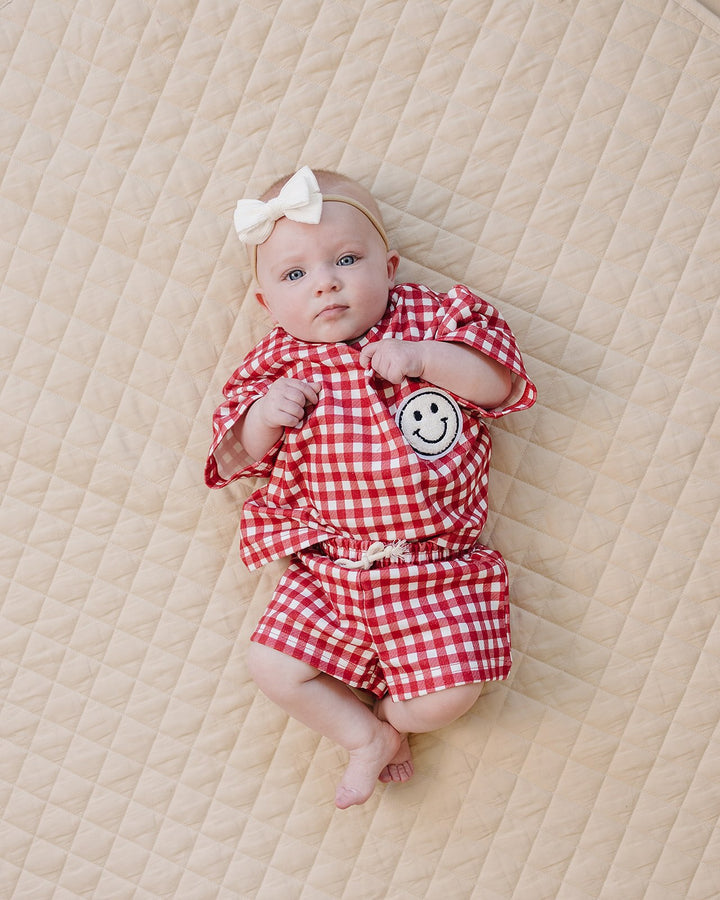 Baby wearing Lucky Panda Kids Red Gingham Shorts Set — gender neutral cotton two-piece with smiley face patch
Lucky Panda Kids Shorts Set Red Gingham flat lay — relaxed top with smiley patch and matching elastic waistband shorts
Toddler in Lucky Panda Kids Red Gingham Shorts Set — sizes 0–3M to 8–9Y, gender neutral summer outfit
Close-up of Lucky Panda Kids Red Gingham Shorts Set smiley face patch — soft 95% cotton kids two-piece
Lucky Panda Kids Red Gingham Shorts Set on baby — gender neutral cotton summer