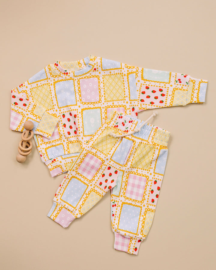 Sweet Patchwork long sleeve top and matching jogger pants laid flat, showing the full pastel print.
