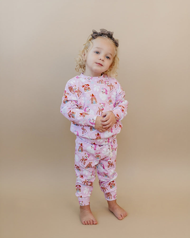 Toddler tilting their head while wearing the Pink Christmas printed top and matching joggers.